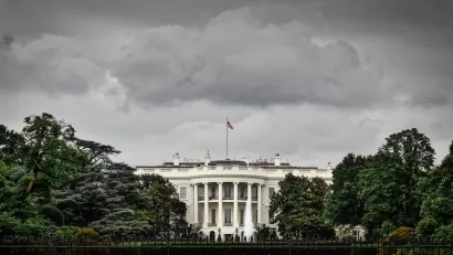 Front of White House with stormy sky above.